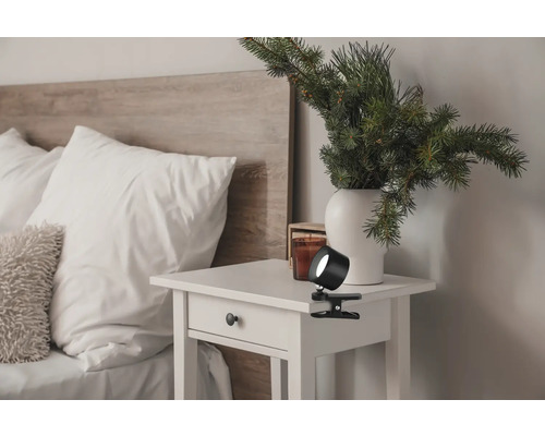 Szene eines Schlafzimmers mit Nachttisch und einer Klemmleuchte