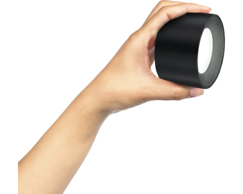 Eine Hand hält eine Rolle Isolierband.