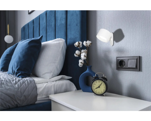 Schlafzimmer mit Bett, Nachttisch, Lampe und Dekoration