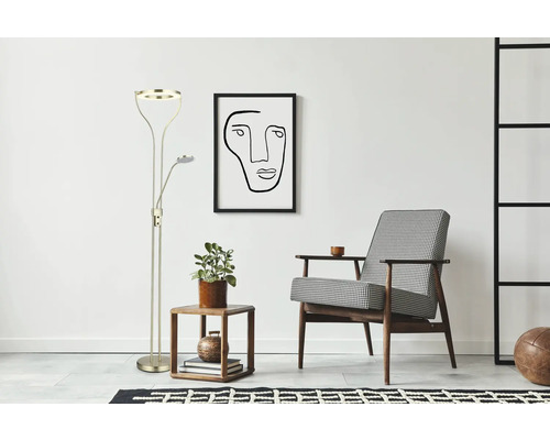 Stehleuchte mit Lesearm neben Beistelltisch und Sessel in einem hellen Raum