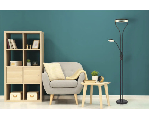 Wohnzimmer-Szene mit Bücherregal, Sessel, Beistelltisch und Stehleuchte