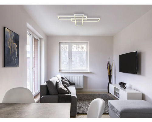 Wohnzimmer mit Sofa, Fernseher und moderner Deckenleuchte