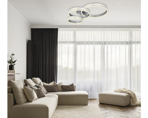 Wohnzimmer mit Sofa und LED-Deckenleuchte in Ringform