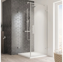 Begehbare Dusche mit Duschkopf und Handbrause vor einer mit geometrischen Fliesen versehenen Wand