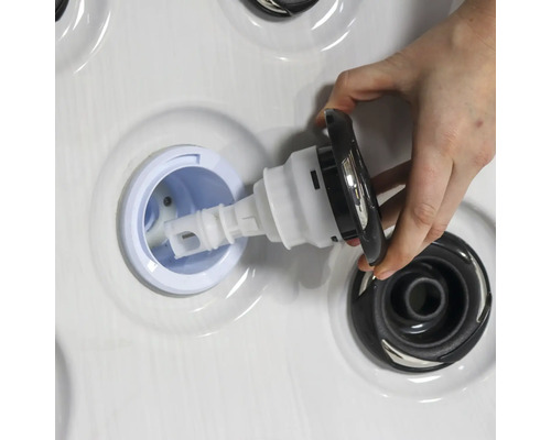 Person setzt Düse in Whirlpool