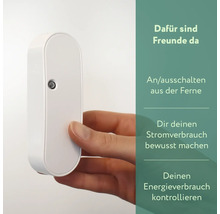 Nahaufnahme eines weißen Smart Home Zwischensteckers, der von einer Hand gehalten wird