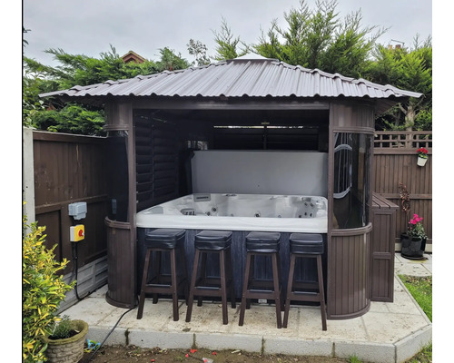 Whirlpool mit Überdachung und Barhockern im Garten