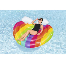 Frau entspannt auf einer regenbogenfarbenen, herzförmigen Luftmatratze im Wasser.
