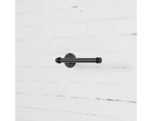 Schwarzer Toilettenpapierhalter aus Metall an einer Wand
