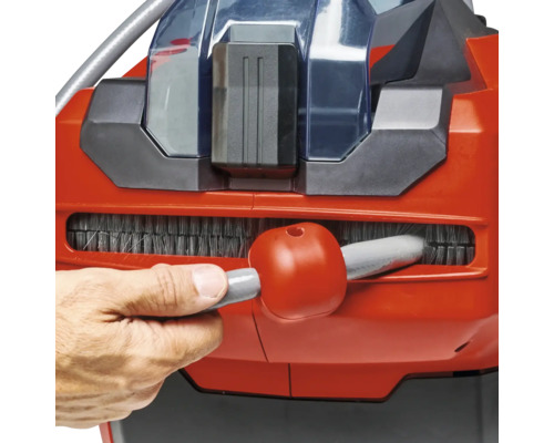 Detailaufnahme einer Person, die eine Bürste eines Staubsaugers reinigt