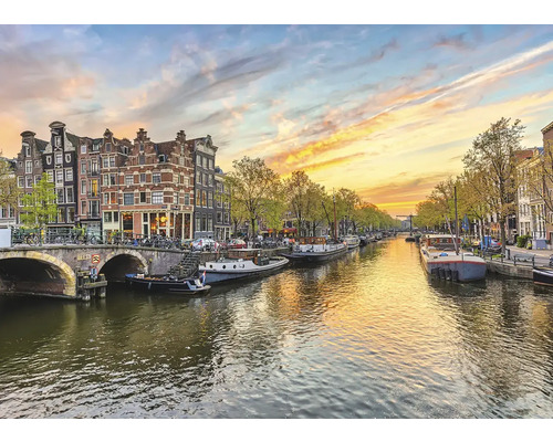Kanalansicht in Amsterdam mit Booten, Brücke und historischen Häusern.