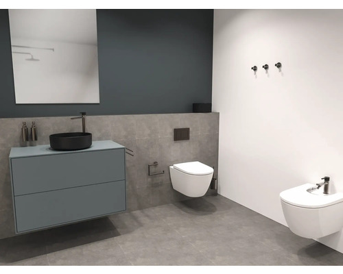 Badezimmer mit Waschtisch, Spiegel, Toilette und Bidet.