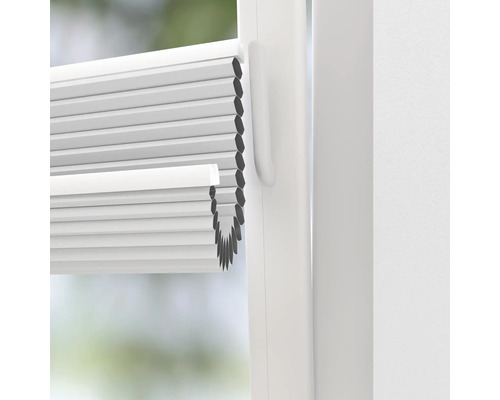 Nahaufnahme einer weißen Plissee-Jalousie am Fenster