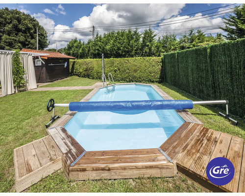 Schwimmbad mit Poolabdeckung, Leiter und Holzterrasse im Garten