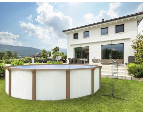 Rundes Aufstellbecken mit Volleyballnetz im Garten vor einem Wohnhaus.