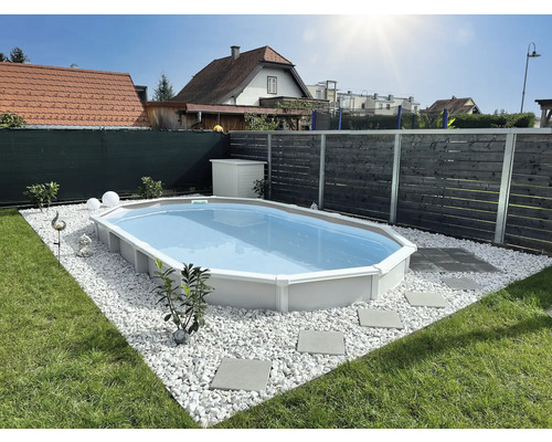 Ovaler Swimmingpool im Garten mit Kiesumrandung