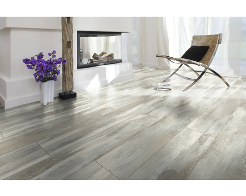 Heller Raum mit Kamin, Sessel und Laminatboden in Holzoptik