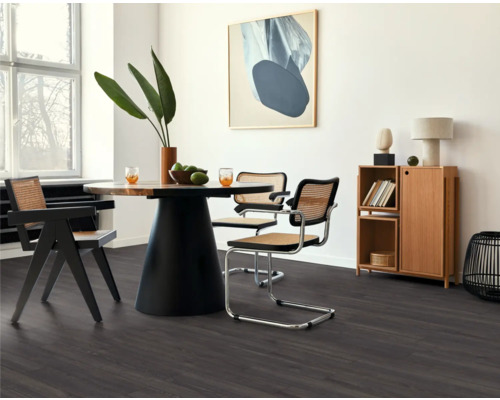 Esszimmer mit Tisch, Stühlen und dunklem Laminatboden.