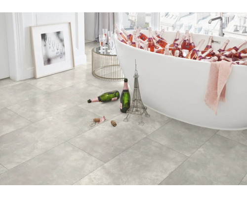 Heller Raum mit Badewanne gefüllt mit Getränkeflaschen, Fliesenboden, Eiffelturm-Dekoration und Bild an der Wand