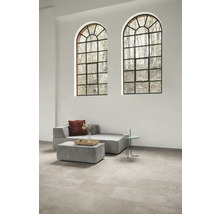 Heller Raum mit Sofa, Tisch und großen Fenstern