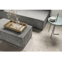 Wohnzimmer mit grauer Couch, Hocker mit Tablett und Beistelltisch