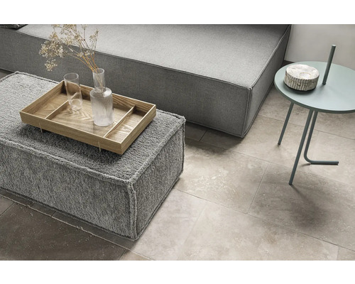 Wohnzimmer mit grauer Couch, Hocker mit Tablett und Beistelltisch