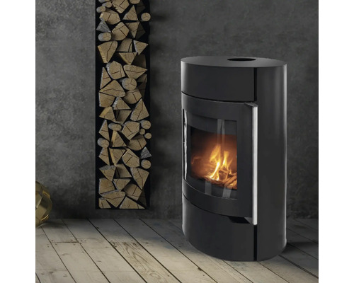 Schwarzer Kaminofen neben einem Holzregal im Raum