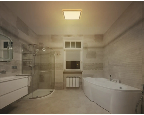 Helles Badezimmer mit Badewanne, Dusche und Waschbecken.