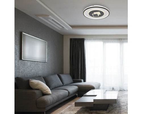 Wohnzimmer mit Sofa, Tisch und runder Deckenleuchte