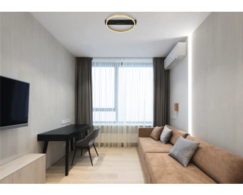 Wohnzimmer mit Sofa, Schreibtisch, Stuhl und Deckenleuchte