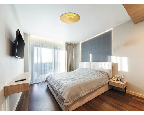 Schlafzimmer mit Bett, Nachttisch, Fernseher und Deckenleuchte