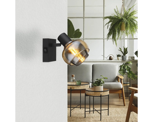 Wandleuchte mit Glaskugelschirm in einem stilvollen Wohnzimmer.