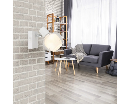 Wohnzimmer mit grauer Couch, Holzboden und Wandlampe