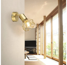 Goldfarbene Wandleuchte mit geometrischem Lampenschirm im Wohnzimmer.
