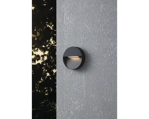 Runde Wandleuchte für den Außenbereich an einer Wand montiert.