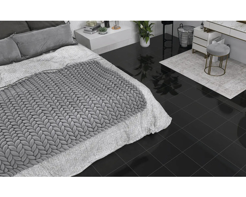 Schlafzimmer und Badezimmer mit dunklen Bodenfliesen, Bett, Kommode und Hocker