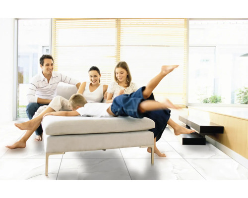 Familie entspannt auf einem Sofa in einem hellen Wohnzimmer mit Fliesenboden.