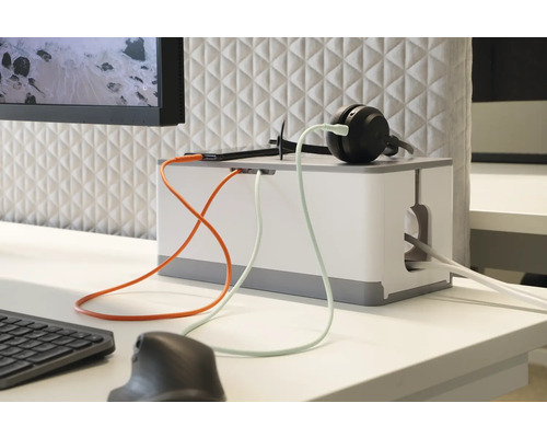Kabelbox auf einem Schreibtisch mit Kopfhörern und elektronischen Geräten für Kabelmanagement