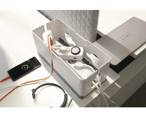 Kabelbox mit Mehrfachsteckdose, Zeitschaltuhr, Kopfhörer und Smartphone auf einem Tisch.