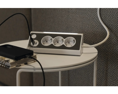 Mehrfachsteckdose mit USB-Anschluss auf einem Tisch mit Ladekabel