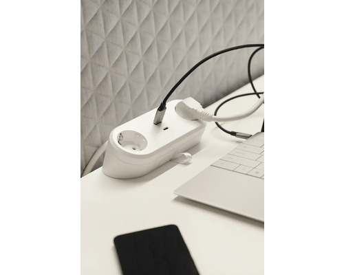 Steckdosenleiste mit angeschlossenen Kabeln auf einem Schreibtisch