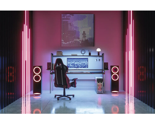 Gamingzimmer mit Schreibtisch, Stuhl, Lautsprechern und Neonbeleuchtung