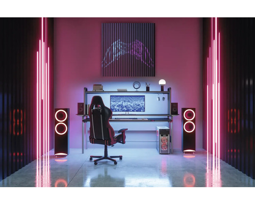 Einrichtung eines Gaming-Zimmers mit Schreibtisch, Stuhl, Lautsprechern und LED-Beleuchtung