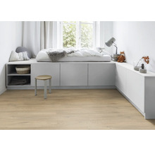 Helles Zimmer mit Holzboden, weißem Podest mit Bett, Ablageflächen und Hocker