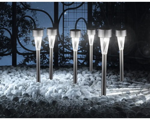 Mehrere Gartenleuchten aus Metall und Kunststoff mit spiralförmigem Lampenschirm auf Kies