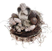 Dekorative Engelsfigur auf einem Nest aus Zweigen und Zapfen