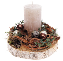 Dekorative Kerze mit Weihnachtsschmuck auf Holzscheibe