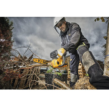 Ein Mann mit Schutzausrüstung verwendet eine DeWalt Kettensäge zum Beschneiden von Ästen.
