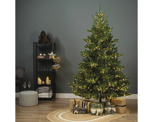 Dekorierter Weihnachtsbaum mit Geschenken auf einem Teppich in einem Zimmer