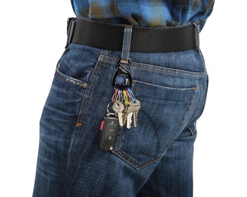 Person mit Schlüsselanhänger, Karabiner und Schlüsseln an einer Gürtelschlaufe der Jeans
